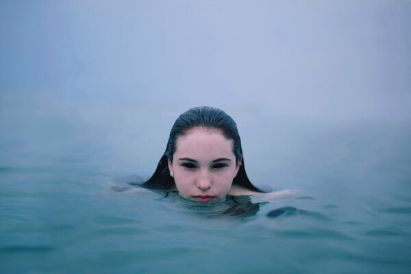 La jeune fille flottant dans la brume d un fleuve, de l eau n est visible que de la tête