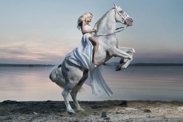 Ragazza in abito bianco si siede su un cavallo bianco. Sullo sfondo del Lago