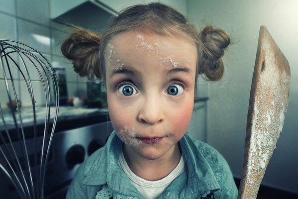 La fille de la maîtresse de la cuisine avec un fouet