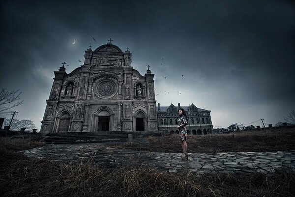 Una chica con un hermoso vestido en el fondo de un monasterio sombrío