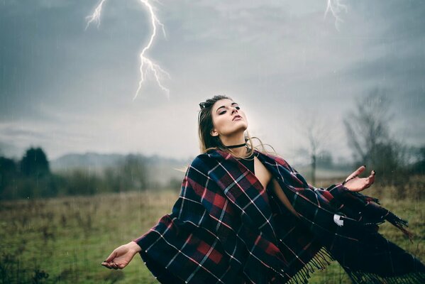 Une promenade dans la tempête. La jeune fille sous la pluie