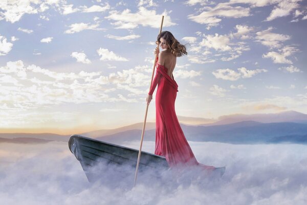 Une belle photo de la fille en robe rouge sur un bateau dans le brouillard