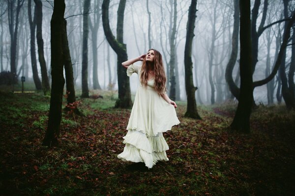 In the morning in the forest, a girl in a dress