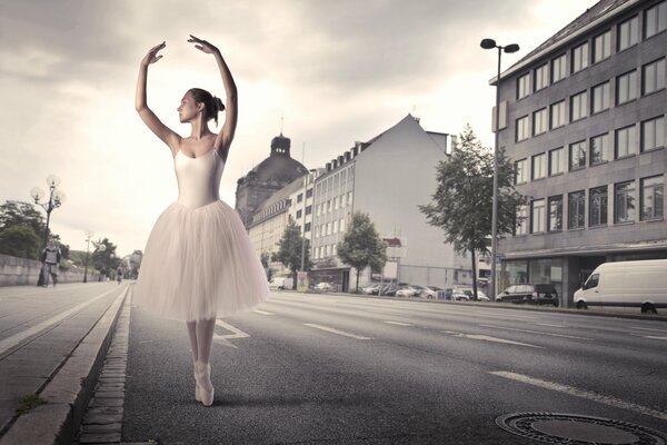 Eine Ballerina steht auf der Straße einer Wüstenstadt