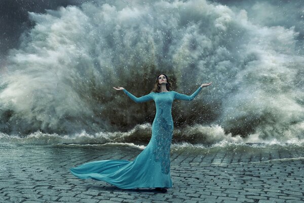 A girl in a turquoise dress on the background of a storm