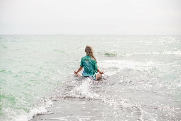 Rubia haciendo yoga en el mar