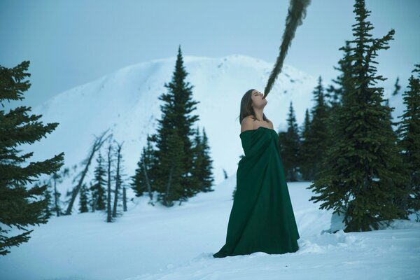 Chica en vestido verde en la nieve