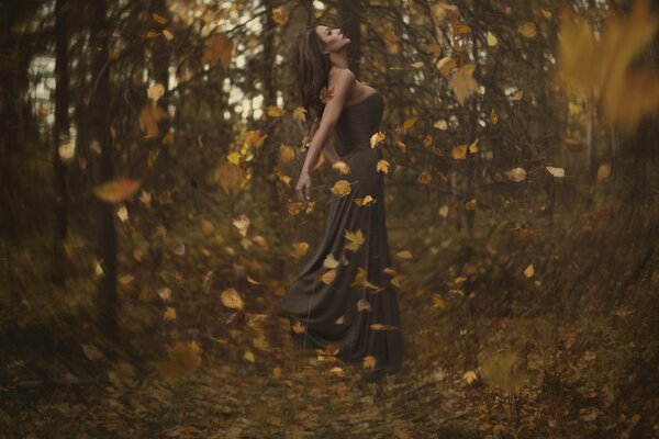 A girl in a whirlwind of leaves