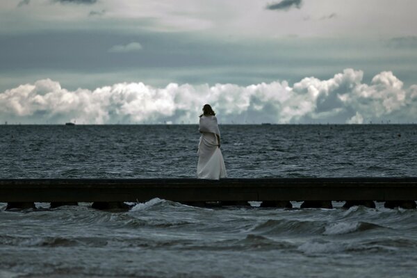 Chica mirando el mar furioso