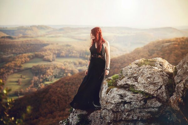 Red-haired model on a rock among rocks