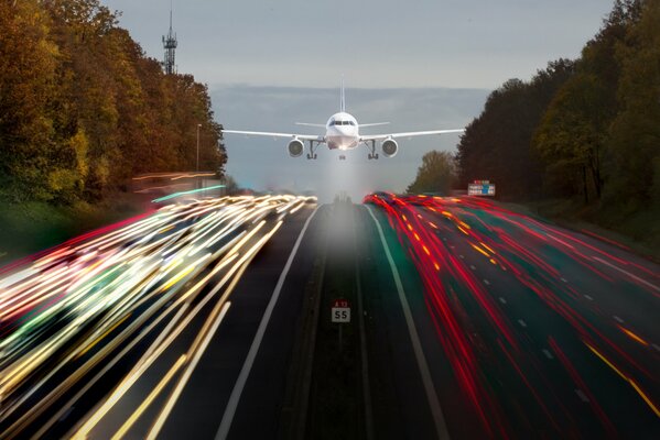 Un avión que vuela bajo sobre una carretera con rayas brillantes