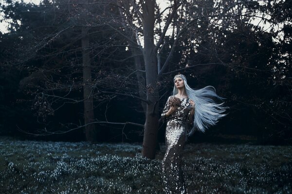 Hermosa foto de una chica con un vestido con el pelo blanco en el bosque