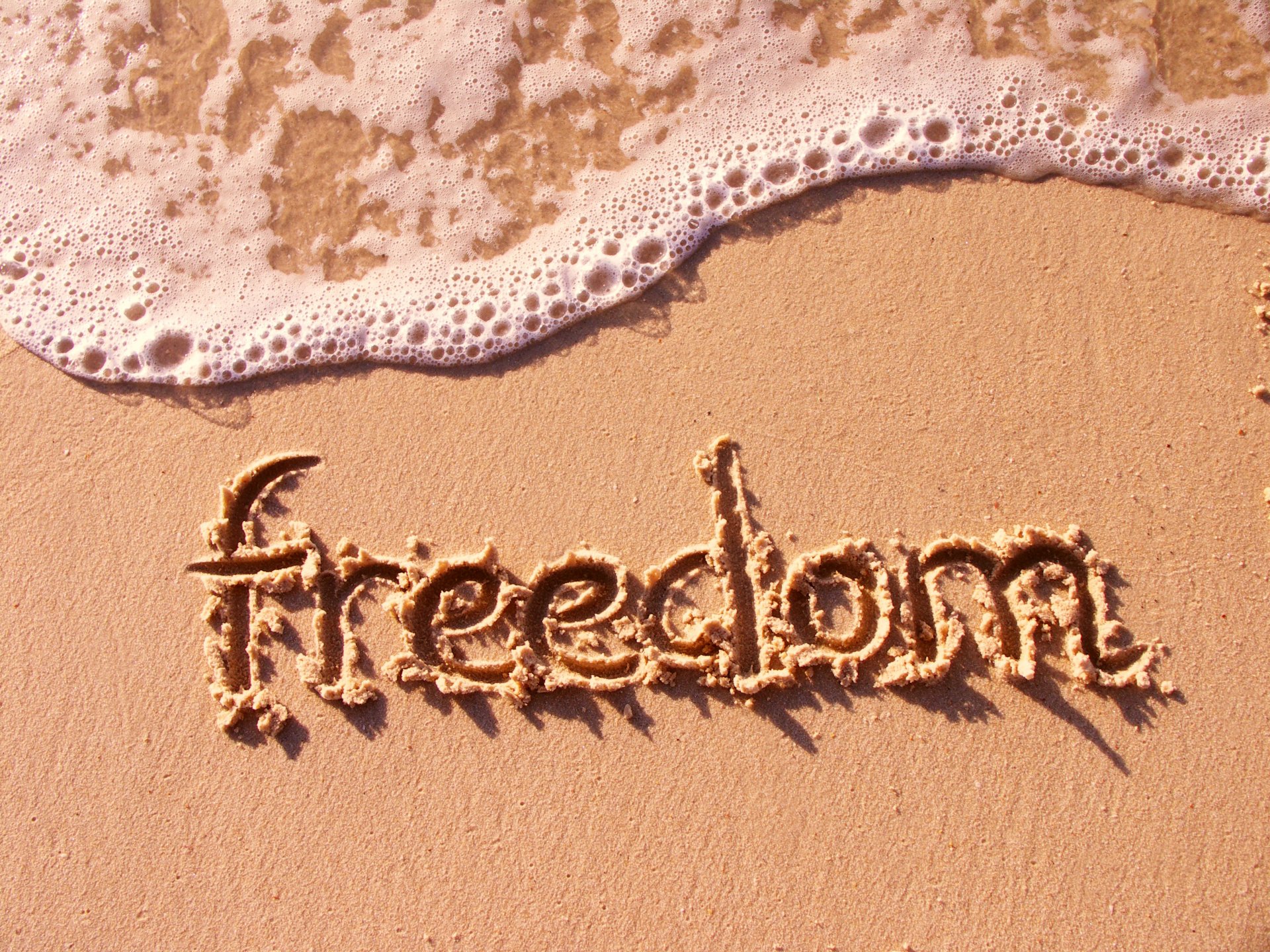 freedom inscription sand wave beach sea mood