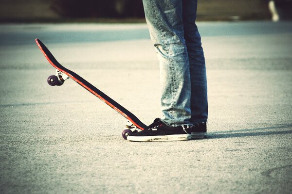 Hombre en jeans en una patineta