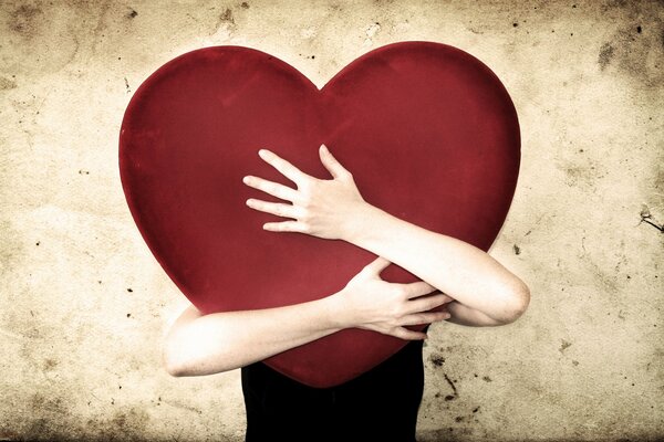 Hands tightly embrace the heart