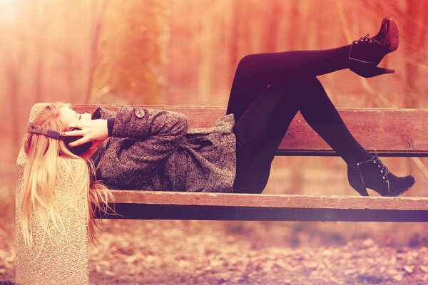 Fille allongée sur un banc dans le parc