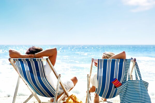 Deux sur la plage se reposent dans des fauteuils