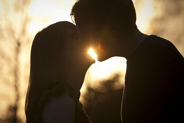 Doux baiser de couple au coucher du soleil