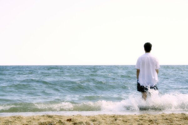 Homme au bord de la mer dans les éclaboussures des vagues