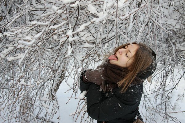 Mädchen fängt Schnee mit der Zunge