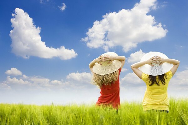 Ragazze in cappello guardando le nuvole nel cielo