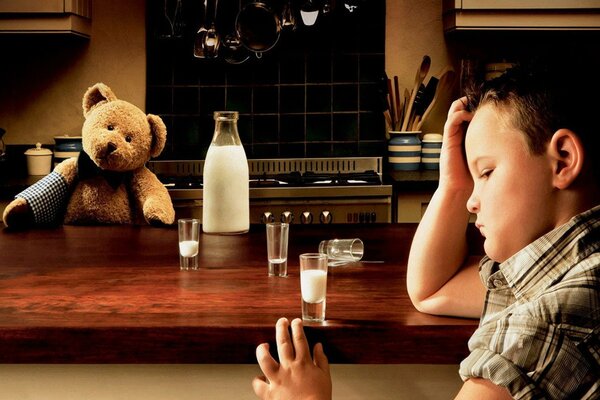 Sad child with a bear and milk