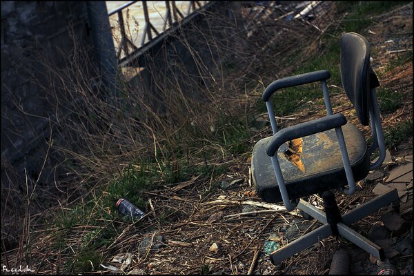 An abandoned place with garbage and a chair