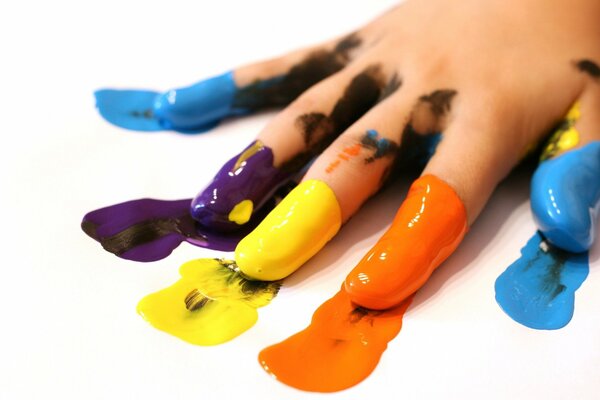 Fingers of the hand painted with different colors of paints