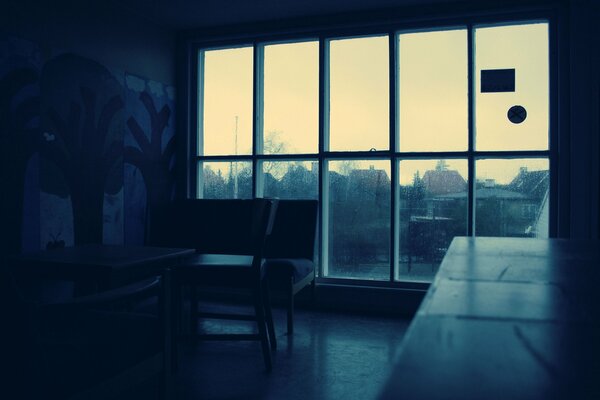 A gloomy room with a large window