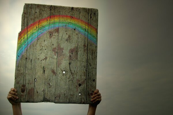 The image of a rainbow on a plaque against a dull gray sky