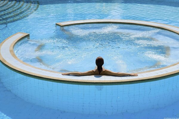 Chica sentada de espaldas en el Jacuzzi