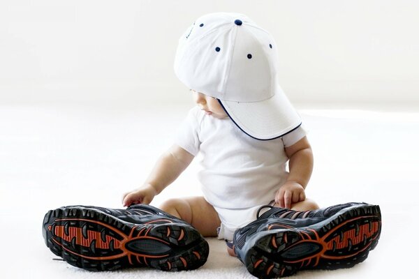 Petit garçon en grandes baskets et casquette blanche