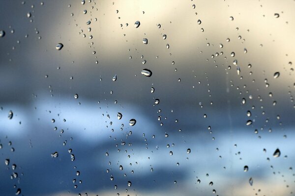 Beaucoup de gouttes sur le verre, et derrière eux le ciel