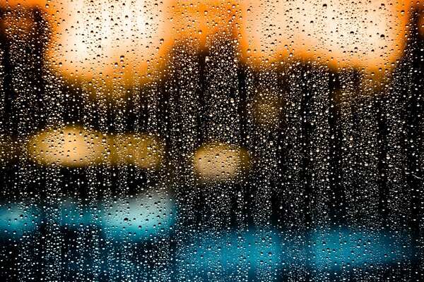 Blurred outlines are visible through the glass with drops