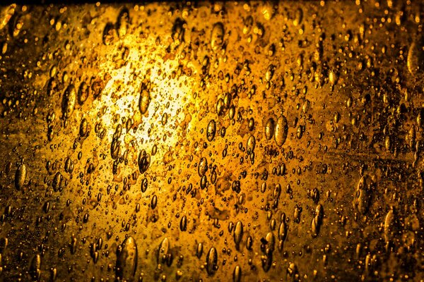 Gotas de aceite de oro iluminadas por linterna