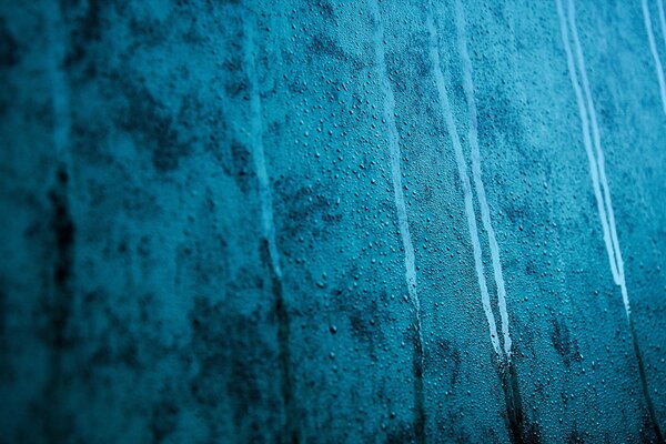 Water drops on the misted blue glass