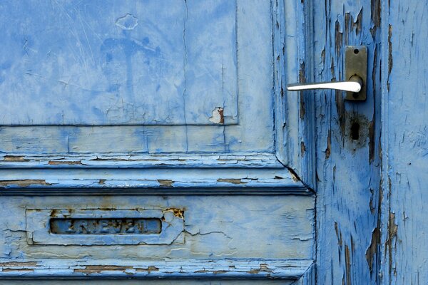 Puerta vieja de color azul con pintura agrietada