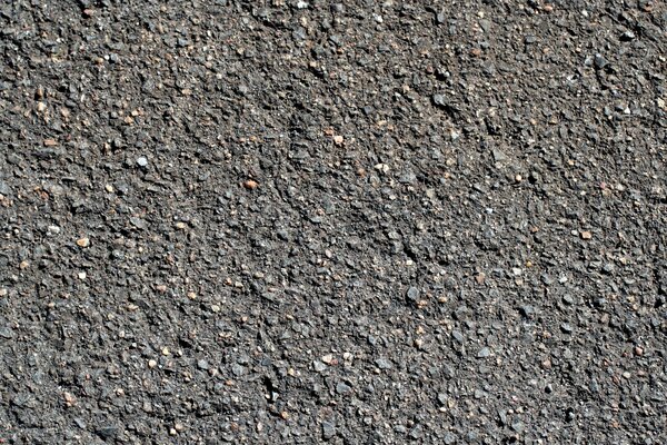 The texture of the asphalt pavement of the road