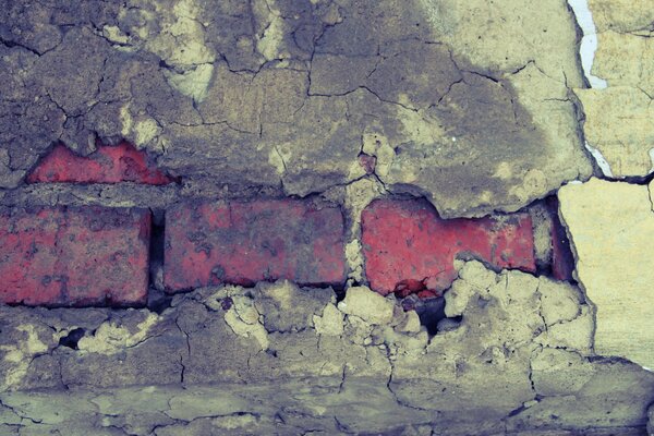 Immagine di un vecchio muro di mattoni arancione e intonaco caduto