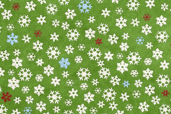 Su uno sfondo verde, i fiocchi di neve di Capodanno sono multicolori