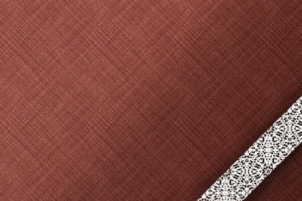 A strip of lace on a burgundy fabric