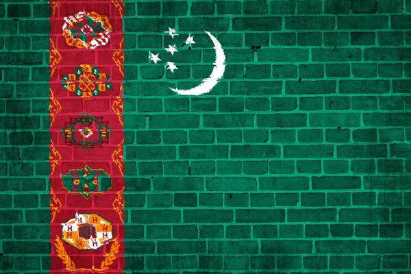 Turkmenische Flagge auf Backsteinmauer Hintergrund