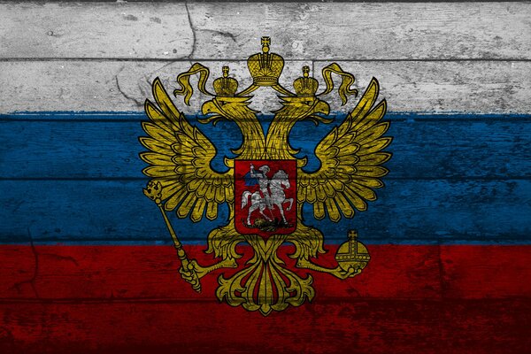 Escudo de armas de Rusia en el fondo tricolor con textura de madera