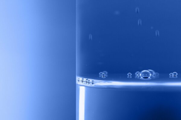 Bubbles in a glass of water on a blue background