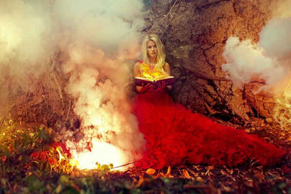 A girl with a book in the forest by the fire