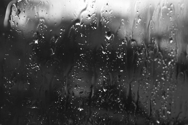 Raindrops roll down the glass