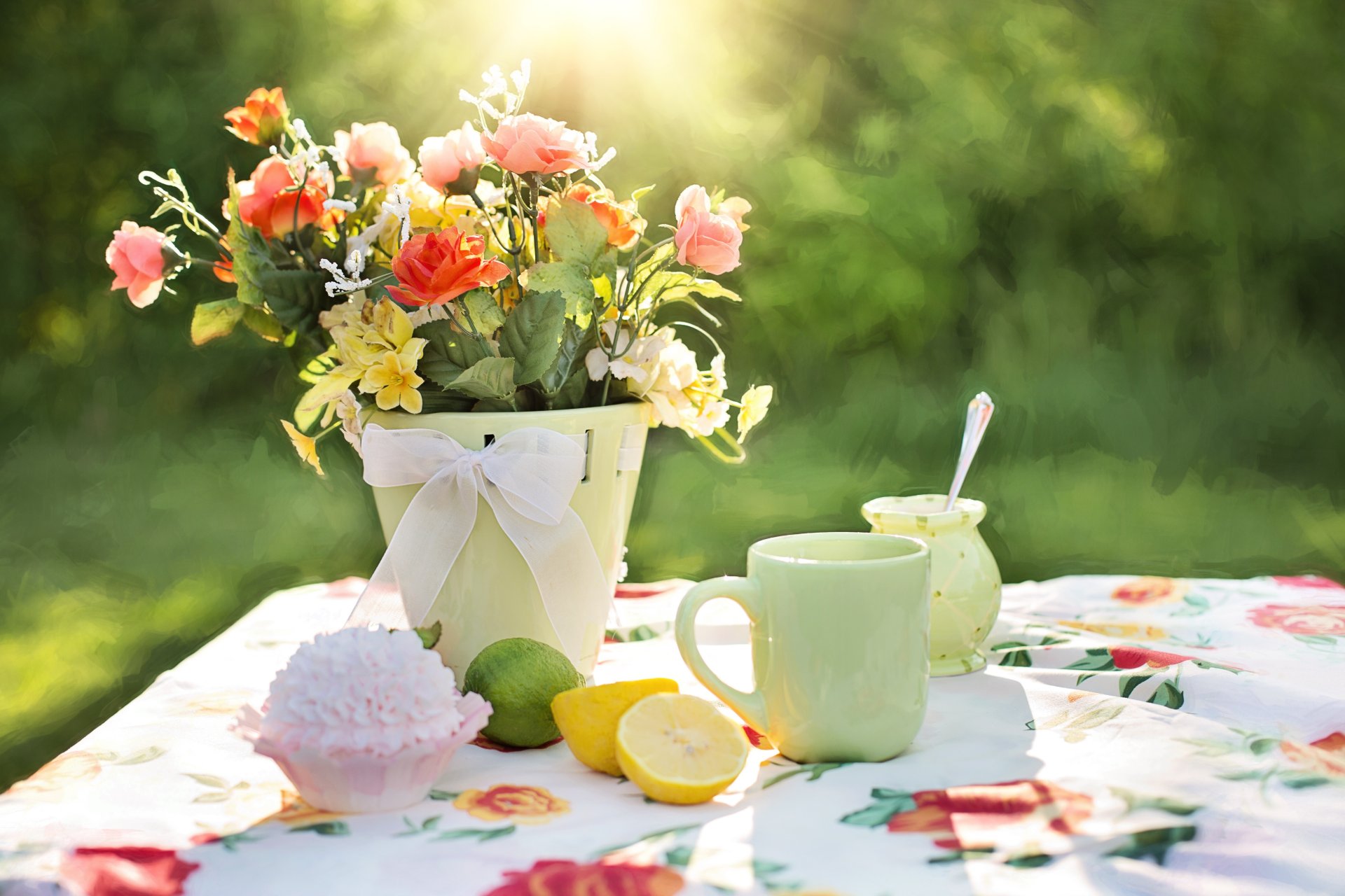 mesa mantel florero flores taza limones pastel