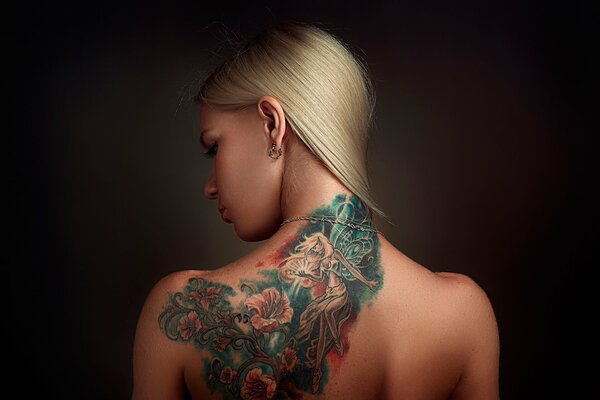 Ragazza con tatuaggio colorato sulla schiena