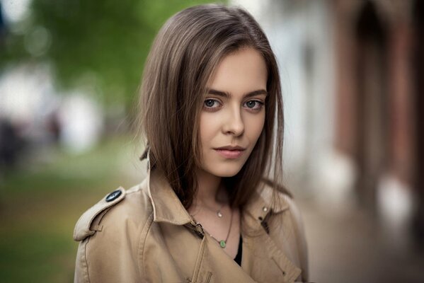 Cute girl in a beige raincoat