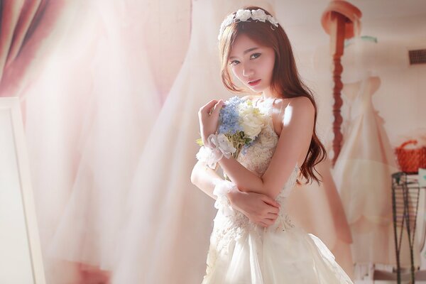 A girl in a wedding dress with a bouquet of flowers